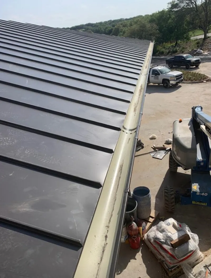 Standing seam panel and gutter detail on a metal roofing jobsite in West Springfield